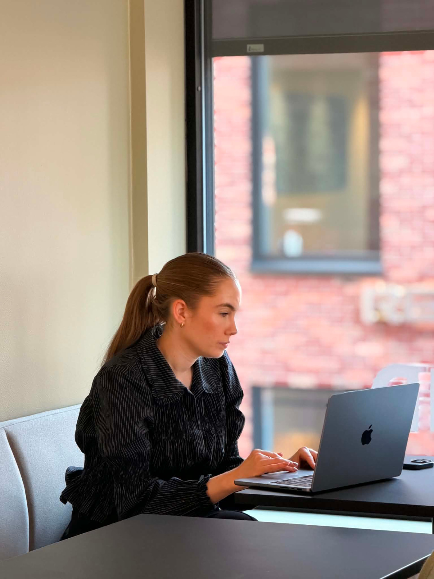 Trine jobber ved vinduet på kontoret